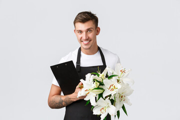 Small business, retail and employees concept. Handsome salesman, delivery guy from flower shop...