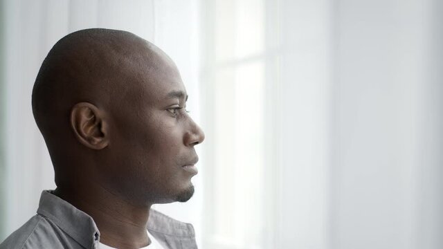 Thoughtful Middle-Aged Black Man Standing Near Window At Home