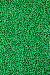 Green granules of polypropylene or polyamide. background. Plastics and polymers industry. Copy space.