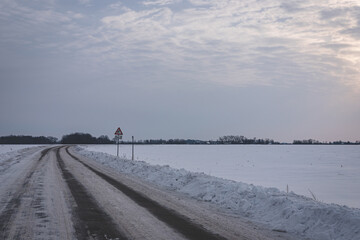 january morning sunrise over agricultural fiel or meadow covered with snow. Minimalist landscape with misty doomy athmosphere