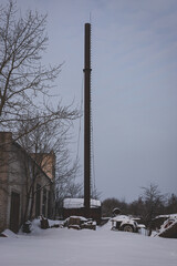 long gray metal chimney pipe in the snow against the sky