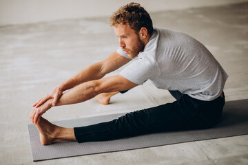 Man practicing yoga on the mat at home