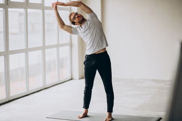 Man practicing yoga on the mat at home