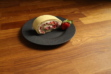 Sahneroulade Stück mit Erdbeeren auf Teller