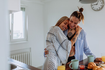Lesbian couple having breakfast at home in the morning with love and tender.