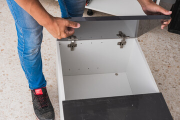 Man installing the doors of a kitchen cabinet