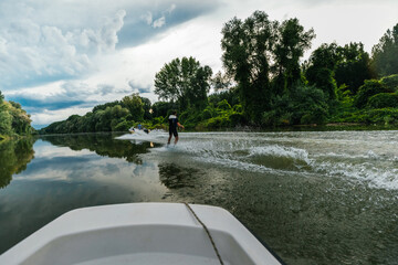 Energetic young guy out wake-boarding on the lake