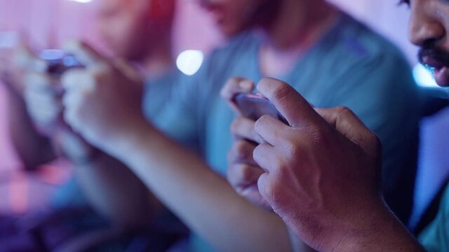 Close up of gamer hand playing video game on mobile phone at esports live tournament match.