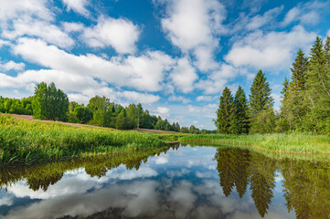 Panoramic landscape of a calm river.A mirror image of Clouds and forests On the Lake.