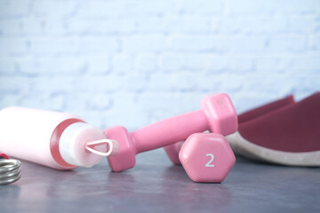  pink color dumbbell, exercise mat and water bottle on white background 
