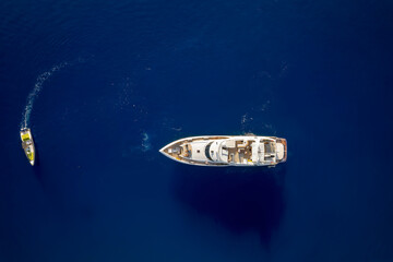 Aerial top down view of a luxury yacht over blue ocean