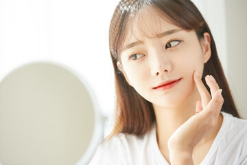 自宅でスキンケアをするかわいい若い女性