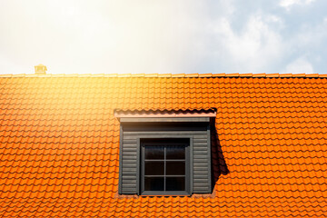 Dormer window on the red clay ceramic tiles roof