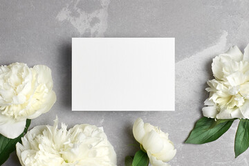 Obraz na płótnie Canvas Card mockup with copy space and white peony flowers on grey