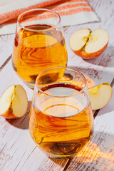 glass of apple juice and sliced apples on a table