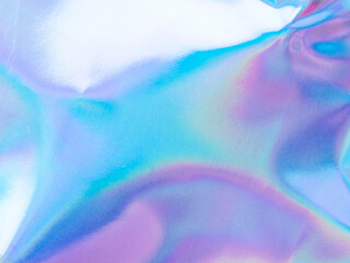 Beautiful holographic rainbow abstract background in pastel and neon color design. Real photography shot of holographic foil for creative project - design fashion, cover, book, printing. Copy space