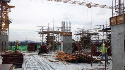 PENANG, MALAYSIA -JUNE 18, 2021: Structural works are underway at the construction site. Construction workers are installing formwork made of metal or timber. Safety features are paramount.
