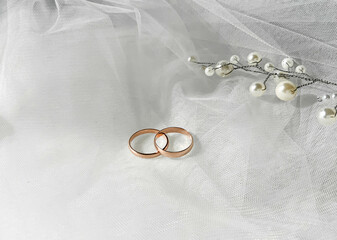 Flat lay background with a pair of gold rings and pearl necklace for wedding or engagement...