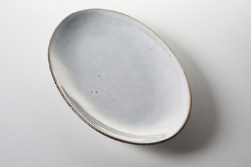Top view of minimalist style oval plate with gray enamel placed on table