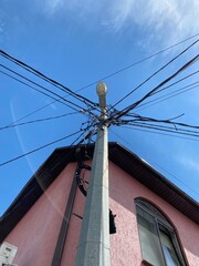Lamppost and wires. The roof and the pink house