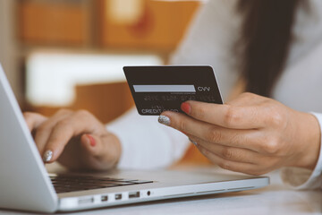 Woman holding smart phone and credit card for shopping online.Blank screen monitor for graphic display montage.Pay for goods by credit card through a smartphone .