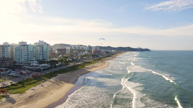 Aerial view of waves at brava beach during scenic sunset, Itajaí, Brazil.