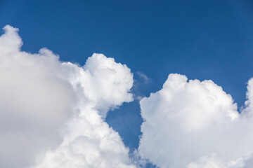 Naklejka na ściany i meble 夏の日の青い空に浮かぶふわふわした雲