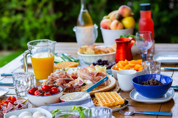 Laid table with food.Breakfast on the terrace.A table with food for a large family.A...
