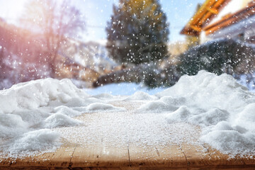 Fresh snow on a wooden table on a beautiful winter day with a landscape background 