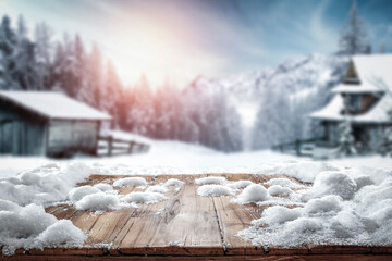 Fototapeta Fresh snow on a wooden table on a beautiful winter day with a landscape background  obraz