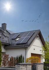 Solar Panel on a dark gable roof - blue sky and sun. Moder house, vertical shot. © MAXSHOT_PL