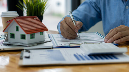Sales representatives work at the desk with home purchase contracts or on office loans and interest rates.
