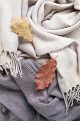 Cashmere, natural beige wool fabric and autumn leaf, texture, top view, concept of winter and autumn comfort