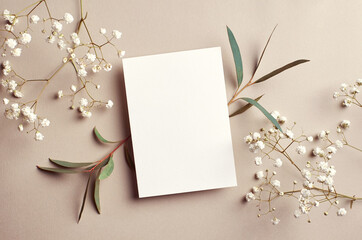 Wedding invitation card mockup with natural eucalyptus and white gypsophila twigs. Blank card...