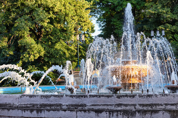 An old fountain with a large bowl in the center and jets of different shapes