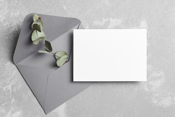 Greeting or wedding invitation card mockup with envelope and dry eucalyptus twig