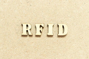 Alphabet letter in word RFID (Abbreviation of Radio-frequency identification) on wood background