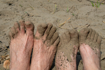 Bare feet on the beach in the sand.