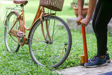selective focus bicycle tires People are pumping bicycle tires on the front lawn The concept of reusing bicycles - obrazy, fototapety, plakaty
