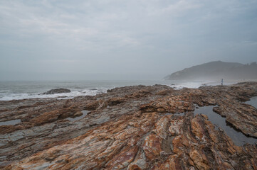 Cloudy seaside, rocks on the beach