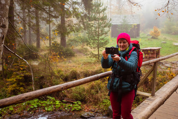 Fototapeta premium Woman is taking a selfie while hiking in the forest