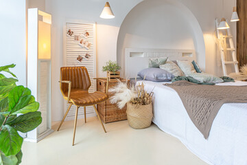Fashionable modern interior of a light studio apartment with wooden columns in the loft style, decorated with brick, marble and wood with stylish furniture and white walls
