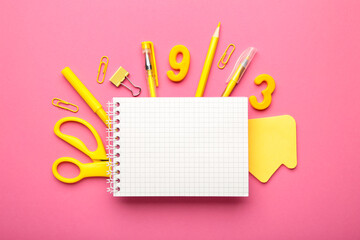 Yellow school supplies with notebook on pink background. Back to school. Flat lay.