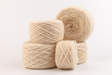 balls of light woolen thread on white background. natural wool. knitting. background