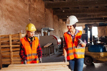 The young women in uniform working in a factory