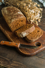 Dark multigrain cereal bread on rustic wooden board