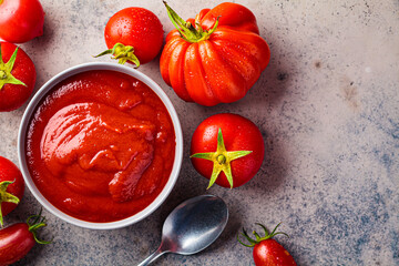 Homemade tomato sauce in gray bowl. Cooking from summer vegetables concept.