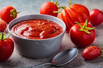 Homemade tomato sauce in gray bowl. Cooking from summer vegetables concept.