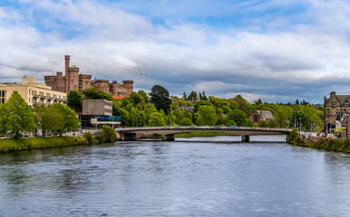Fototapeta premium A view down the River Ness towards castle and the Ness Bridge in Inverness, Scotland on a summers day