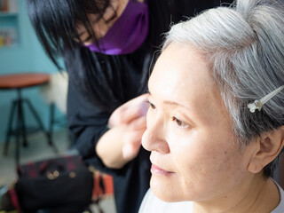 Senior asian woman and make up artist.